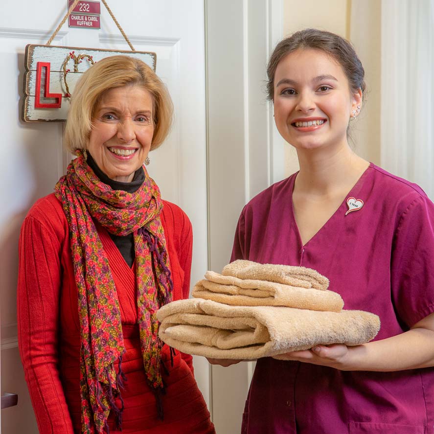 A team member delivering fresh linens to a resident at Camden Springs